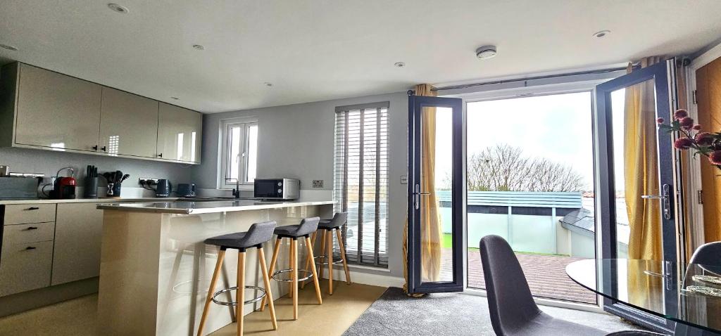 a kitchen with bar stools and a view of a balcony at The Philog by Switchback Stays in Cardiff