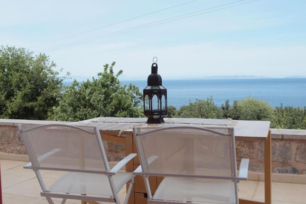 Seaview lovely Villa في ليونيديون: كرسيين وطاولة مع مصباح على الفناء