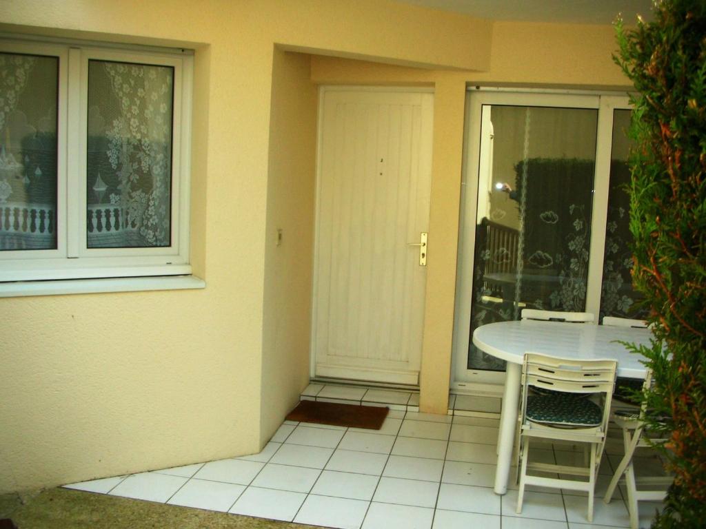 une terrasse avec une table et des chaises à côté d'une maison dans l'établissement Appartement T2 à 100m du marché central et 500m de la plage à Royan - FR-1-71-53, à Royan