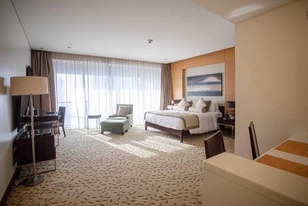 una grande camera d'albergo con un letto e una sedia di The Address Dubai Mall Residences - Deluxe Studio a Dubai