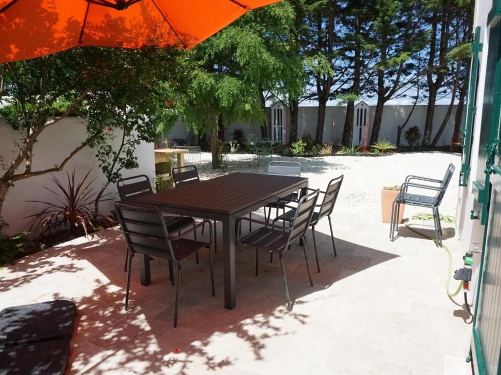 濱海拉庫阿爾德的住宿－Villa La Couarde-sur-Mer, 6 pièces, 6 personnes - FR-1-258-98，一把伞下的木桌和椅子