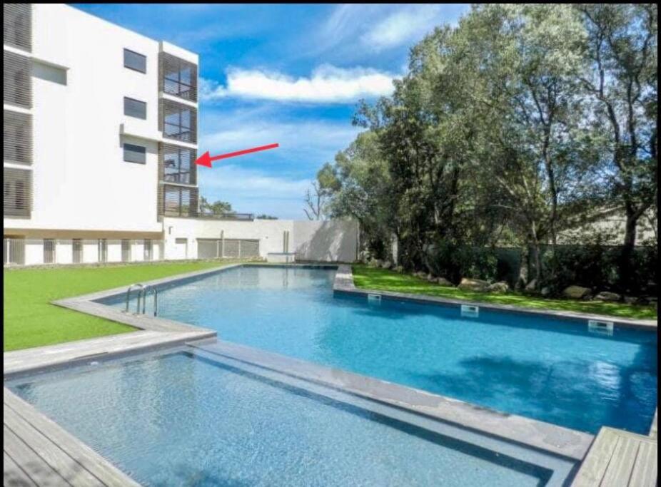 une grande piscine devant un immeuble dans l'établissement Studio Piscine, 200m port de Porto Vecchio pour 2 personnes, à Porto-Vecchio