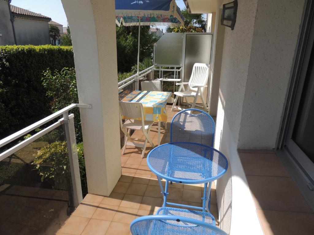 - un balcon avec deux chaises bleues et une table dans l'établissement Royan : T2 cosy avec terrasse, proche plage et commerces, parking privé - FR-1-71-63, à Royan