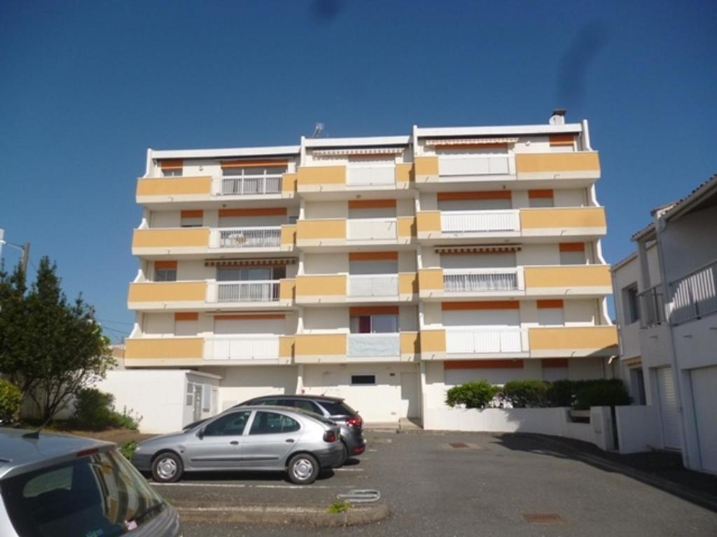a large apartment building with cars parked in a parking lot at Appartement Royan, 2 pièces, 4 personnes - FR-1-71-62 in Royan