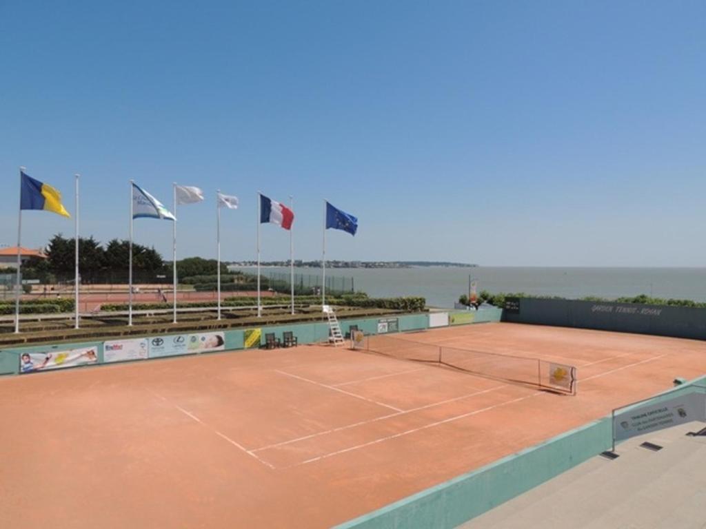 a tennis court with flags on top of it at Appartement Royan, 2 pièces, 4 personnes - FR-1-71-62 in Royan