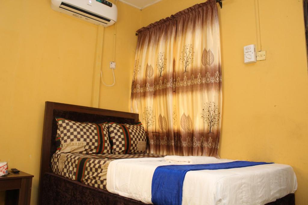 um quarto com uma cama e uma janela com cortinas em JOEL'S HOTELS & SUITES em Ikeja