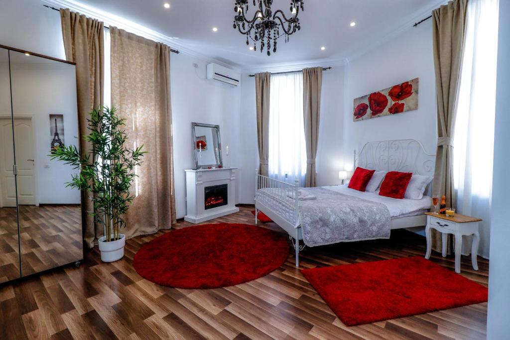 una camera con letto bianco e tappeti rossi di Downtown Central University Apartament - CAL1 a Bucarest