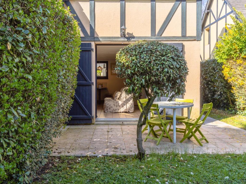 a table and chairs in front of a building at Holiday Home Le Clos du Golf-2 by Interhome in Cabourg