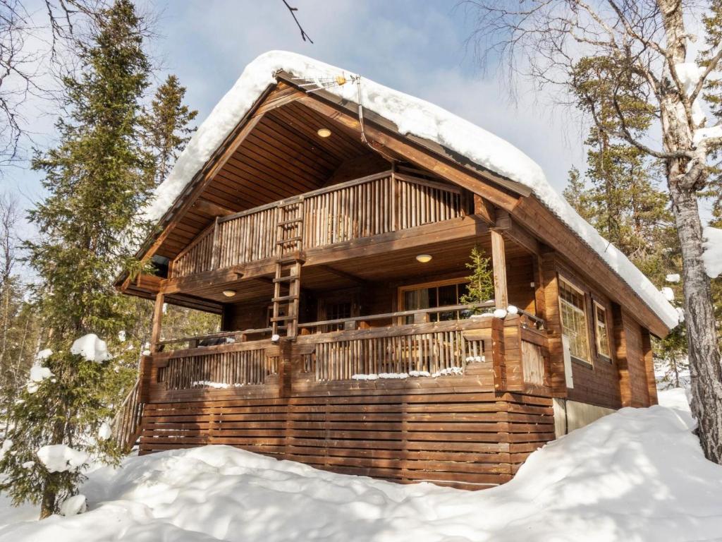 ルオストにあるHoliday Home Mervinrinne by Interhomeの雪の森の丸太小屋