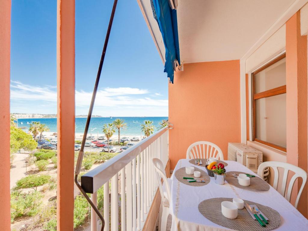 uma varanda com uma mesa e vista para a praia em Apartment Le Méditerranée-1 by Interhome em Fréjus