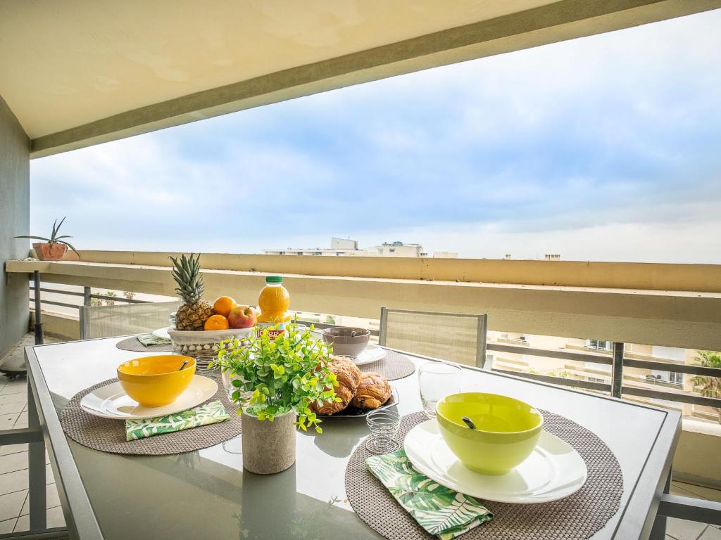 een tafel met kommen en borden eten op een balkon bij Apartment Le Beaupré-21 by Interhome in Canet-en-Roussillon