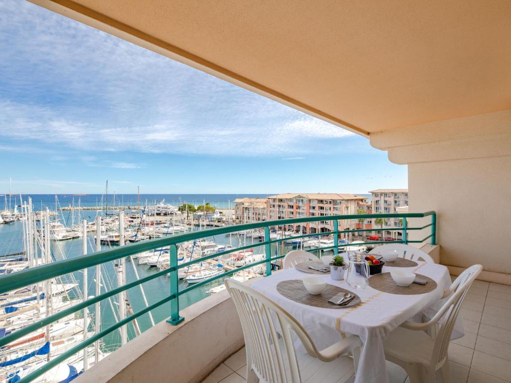 un balcon avec une table et des chaises et une vue sur un port dans l'établissement Apartment L'Open-4 by Interhome, à Fréjus