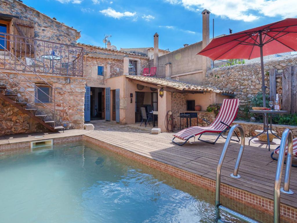 une maison avec une piscine et un parasol rouge dans l'établissement Holiday Home Can Xerret by Interhome, à Sencelles