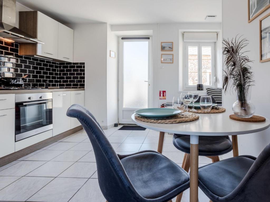 a kitchen with a table and chairs in a room at Holiday Home L'oyat by Interhome in Pirou