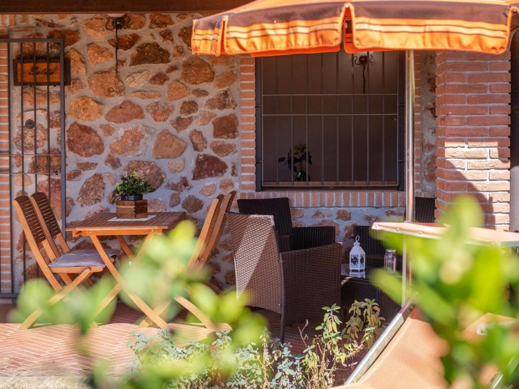 eine Terrasse mit einem Tisch, Stühlen und einer Steinmauer in der Unterkunft Holiday Home Lavanda by Interhome in La Pesta