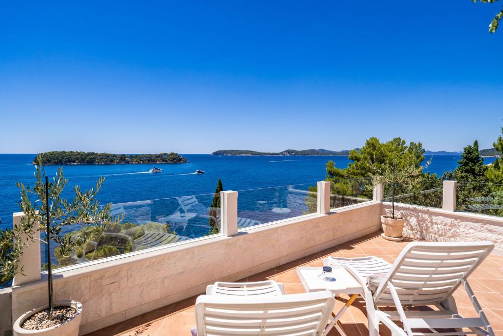 a balcony with chairs and a view of the water at Apartments Lovro in Dubrovnik