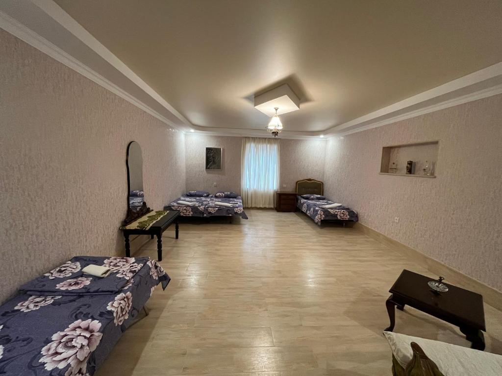 ein Krankenhauszimmer mit 3 Betten und einem Tisch in der Unterkunft Kutaisi City Heart Apartment in Kutaissi