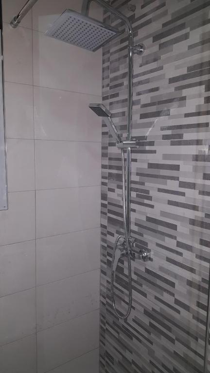 a shower in a bathroom with a tile wall at luxmar beach in Benidorm