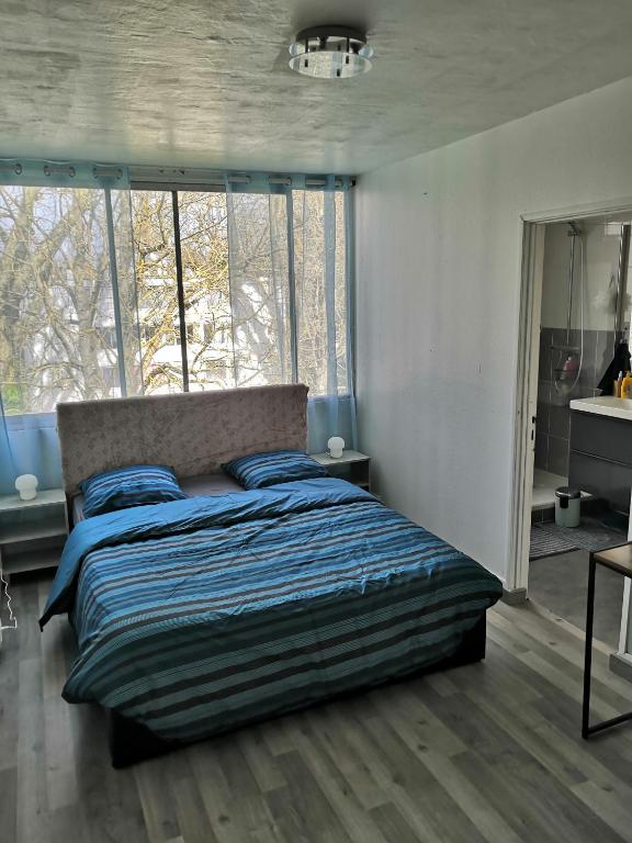 1 dormitorio con cama y ventana grande en Chambre d'hôte au PARC DES THIBAUDIERES en Boussy-Saint-Antoine