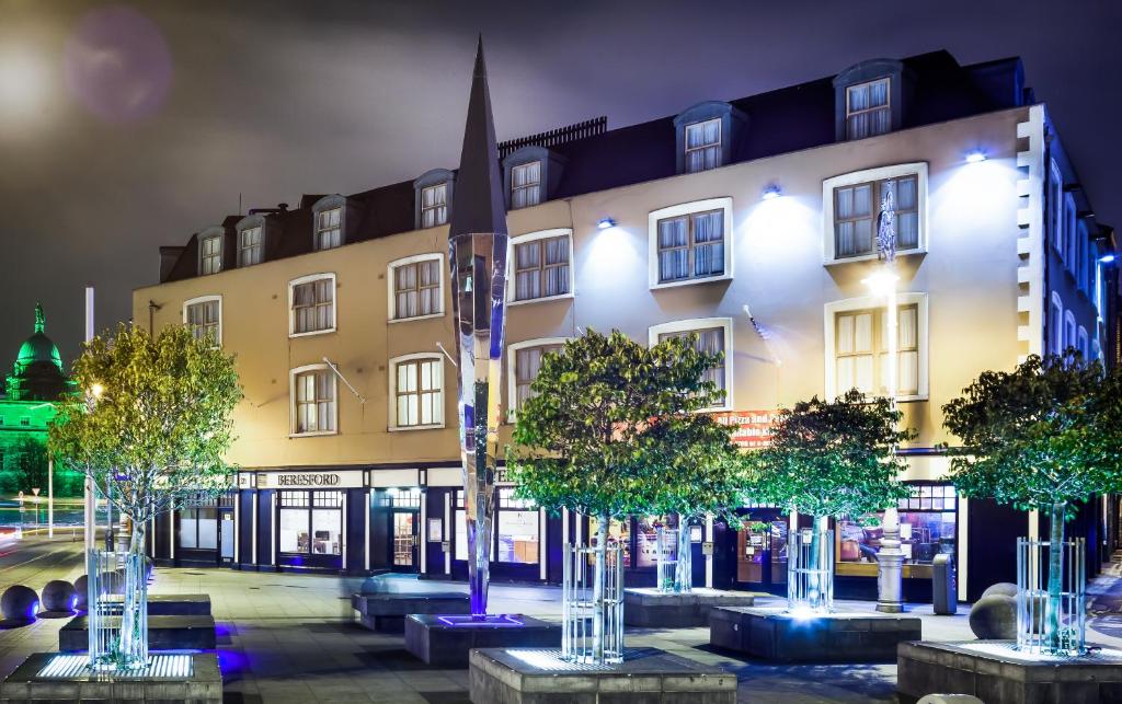 un edificio con una fila de árboles delante de él en Beresford Hotel en Dublín