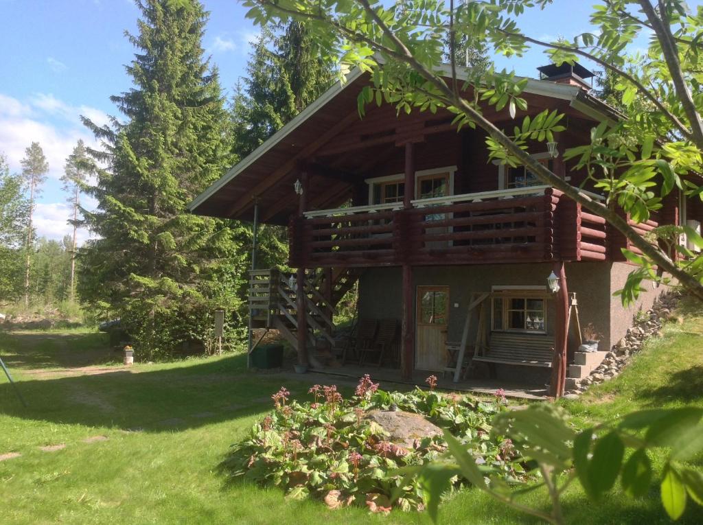 a log cabin in the woods with a yard at Päivänsäde Cottage in Toivakka