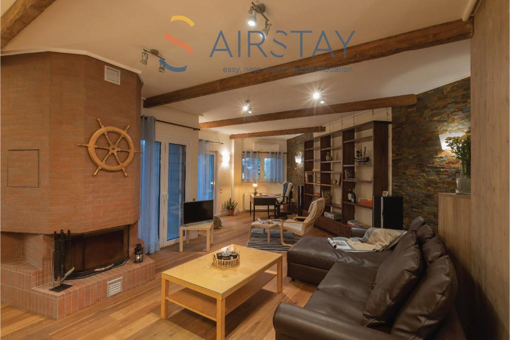 a living room with a couch and a fireplace at Kalista apartment Airport by Airstay in Spata