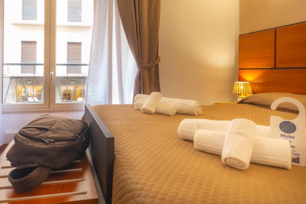 a bedroom with two beds with towels and a bag at Hotel City Center in Palermo