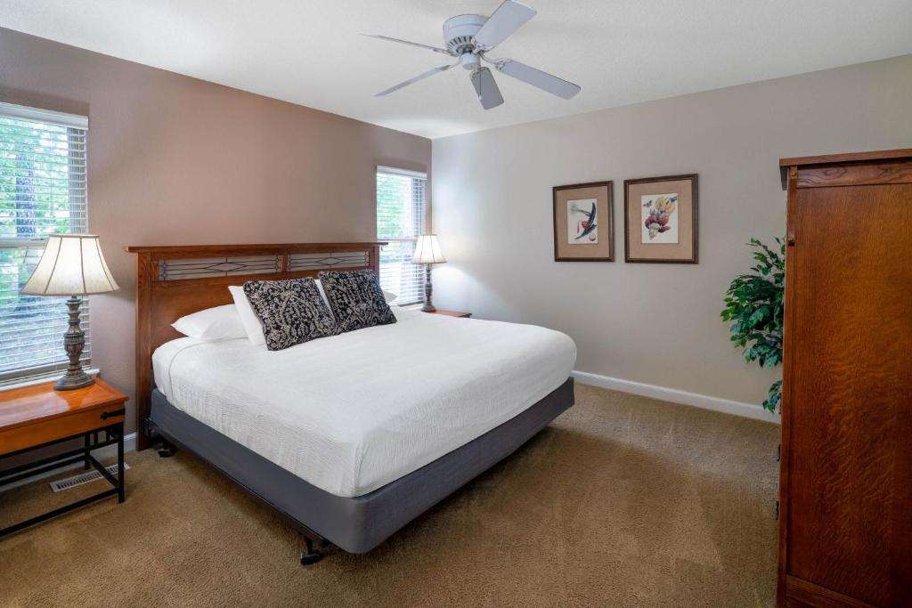 um quarto com uma cama e uma ventoinha de tecto em Los Lagos at Hot Springs Village a Ramada by Wyndham em Hot Springs Village