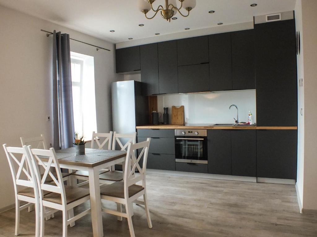 cocina y comedor con mesa y sillas en Apartament Plac Piastowski 1, en Jelenia Góra
