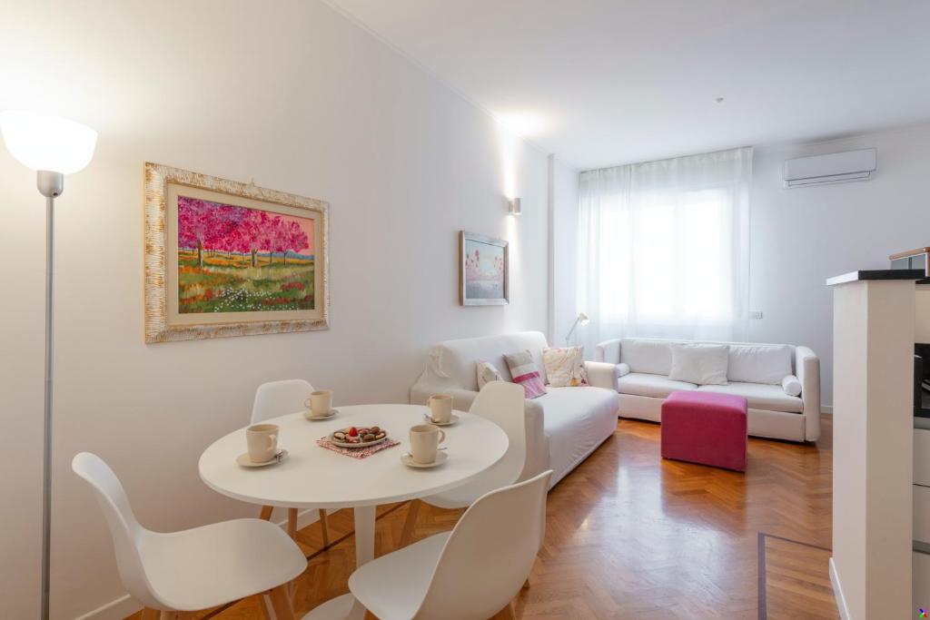 a white living room with a white table and chairs at BnButler - Verona 12, Porta Romana District in Milan