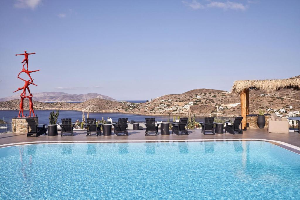 a swimming pool with chairs and a view of the ocean at Liostasi in Ios Chora