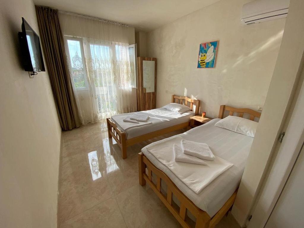 a bedroom with two beds and a television in it at GUEST HOUSE OCEAN FORCE in Batumi