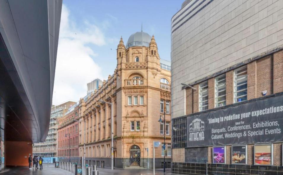 a large building with a clock tower in a city at City Center Leicester in Leicester