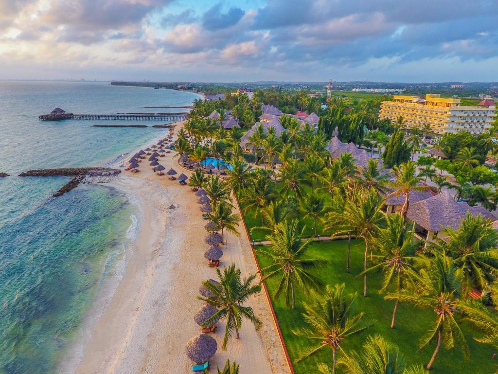 an aerial view of a beach with palm trees and the ocean at White Sands Hotel in Dar es Salaam