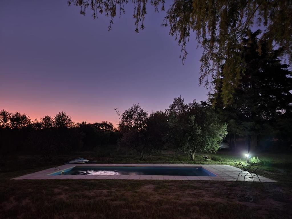 una piscina en medio de un patio por la noche en SANTA MARIA REINA en San Rafael