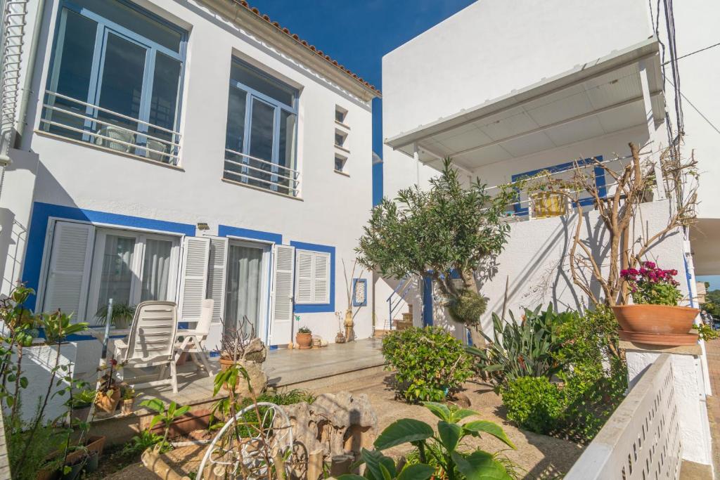 a white house with blue trim and a patio at Casa Acogedora in Portocolom