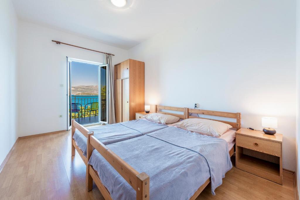 a bedroom with a bed and a view of the ocean at Apartmani Ivušić in Dubrava