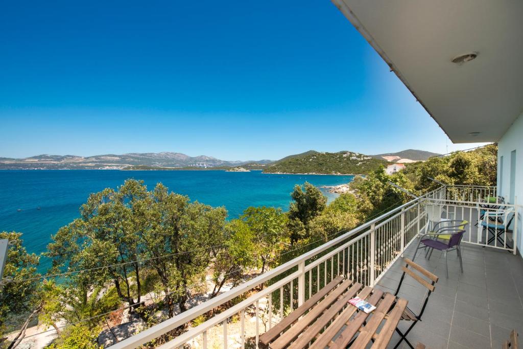 a balcony with chairs and a view of the water at Apartmani Ivušić in Dubrava