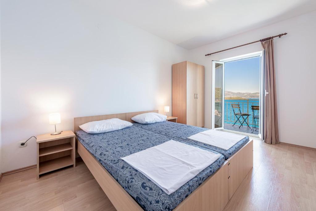 a bedroom with a bed with a view of the ocean at Apartmani Ivušić in Dubrava