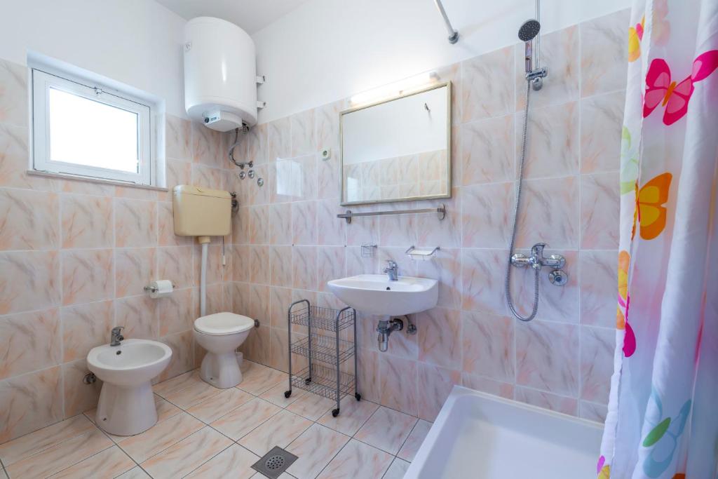a bathroom with two toilets and a sink and a shower at Apartmani Ivušić in Dubrava