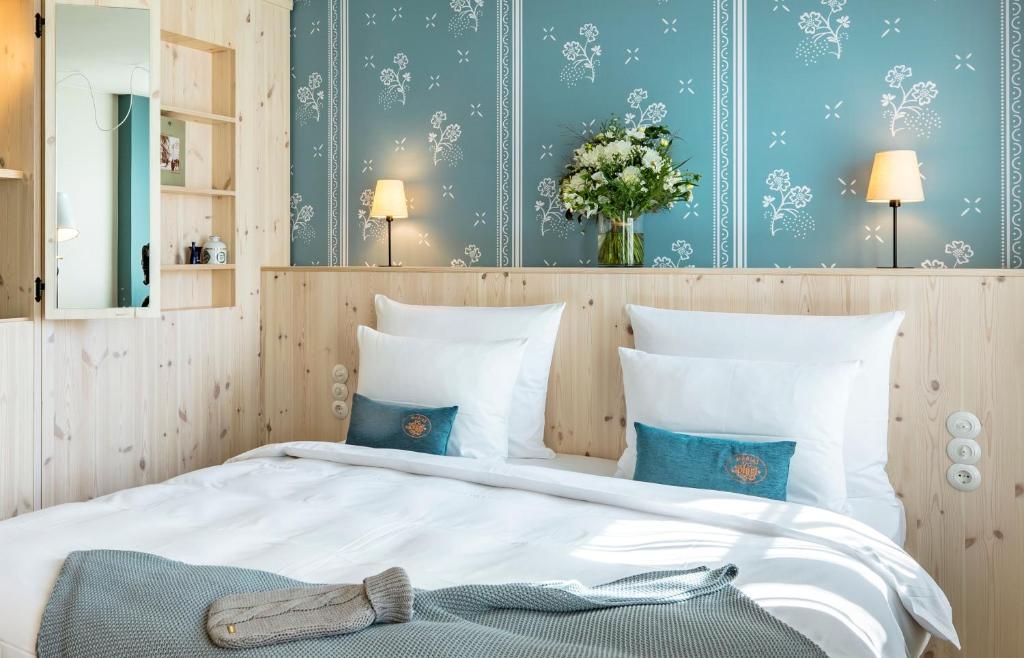 um quarto com uma grande cama branca com paredes azuis em Marias Platzl em Munique