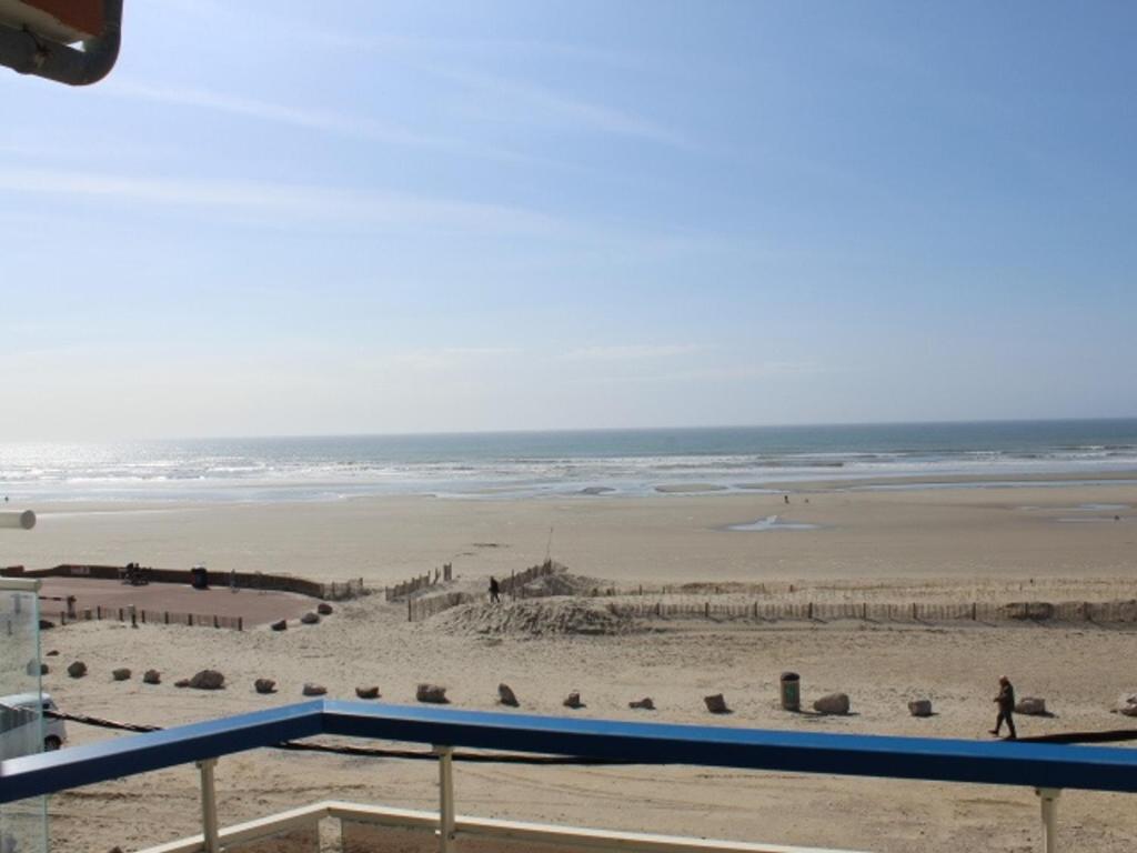 une vue sur la plage depuis le balcon d'un immeuble dans l'établissement Fort-Mahon-Plage : Appartement cosy à deux pas de la mer, animaux admis, parking privatif - FR-1-482-27, à Fort-Mahon-Plage