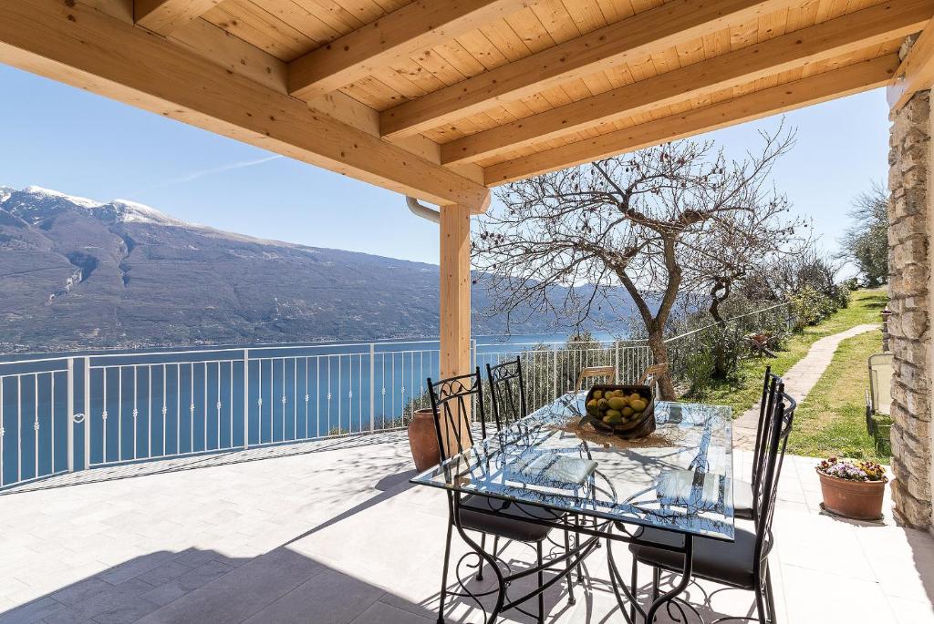 a patio with a table and chairs on a deck at Glicine by Garda FeWo in Tignale