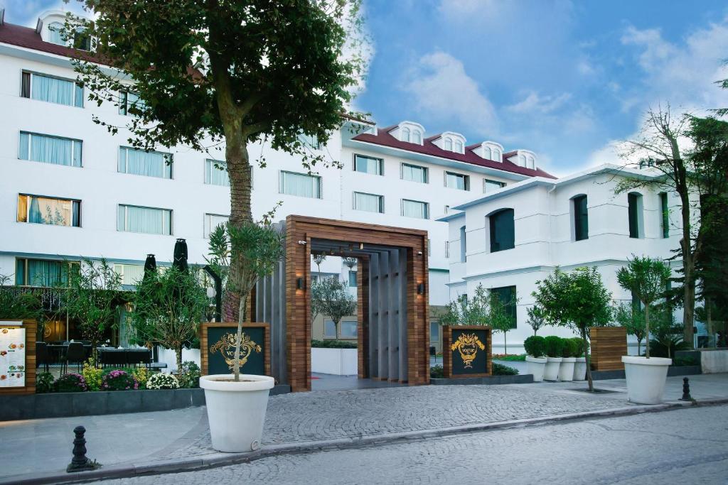 Vogue Hotel Supreme Istanbul في إسطنبول: مبنى ابيض كبير امامه باب خشبي