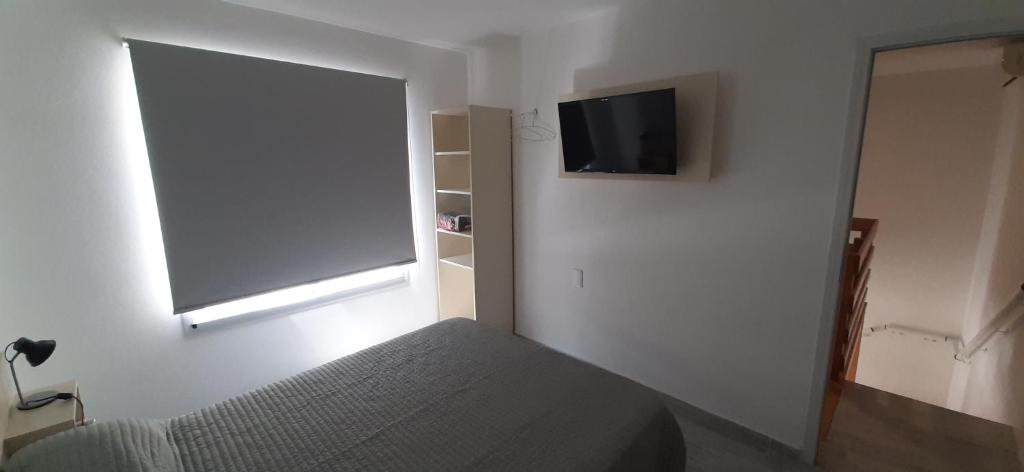 1 dormitorio con 1 cama y TV de pantalla plana en Giara Aparts. en Villa María