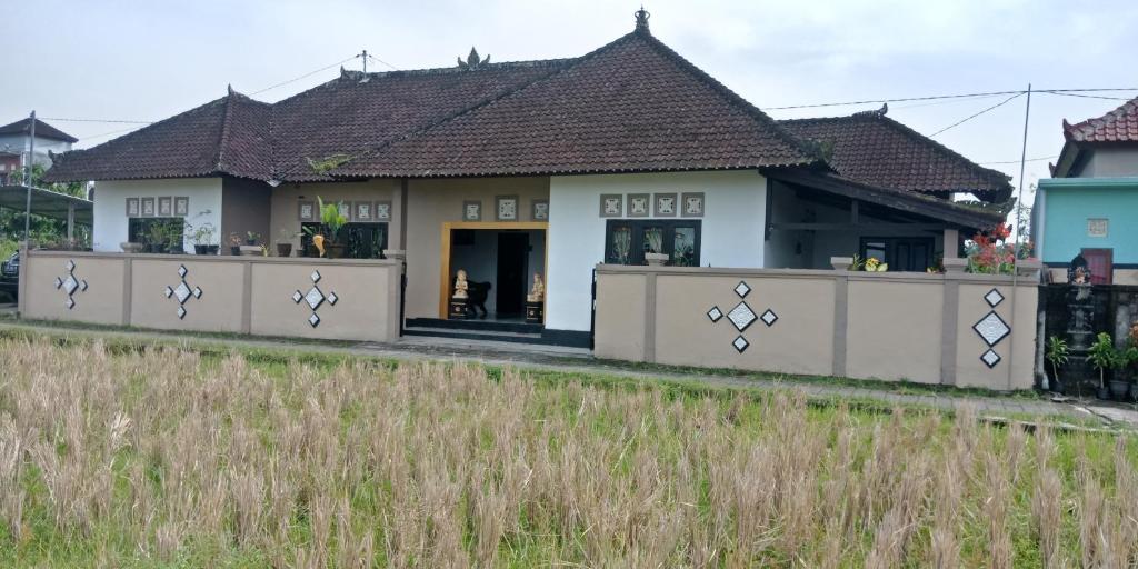 una casa con una recinzione di fronte di Ibu Ana Homestay a Tabanan