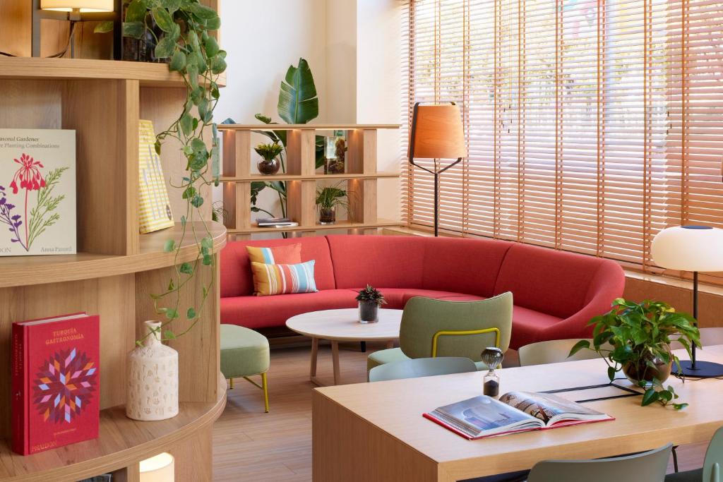 a living room with a red couch and a table at INNSiDE by Meliá Barcelona Apolo in Barcelona