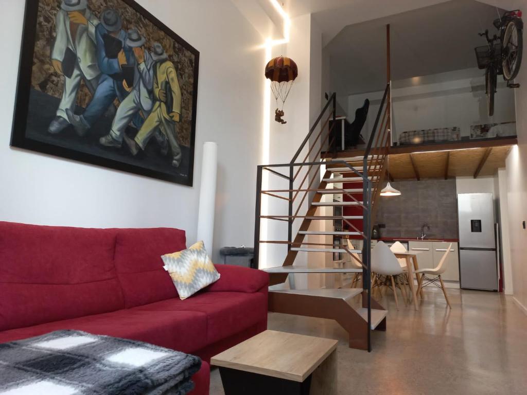 a living room with a red couch and a staircase at Loft Nou Benicalap in Valencia