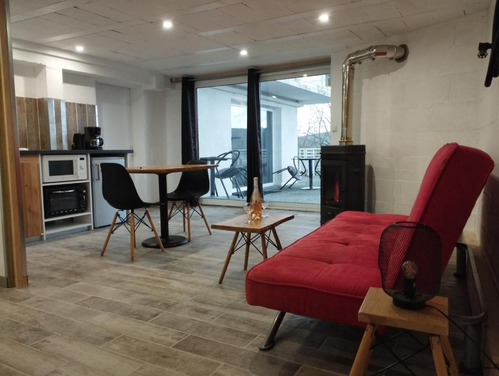 sala de estar con sofá rojo y mesa en Best Price #1 "L'ANN'EXE" x4 people, en Orchamps-Vennes