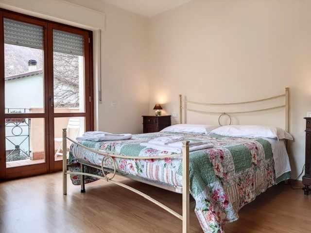 a bedroom with a bed and a large window at Ospitaci Nocera Umbra in Nocera Umbra
